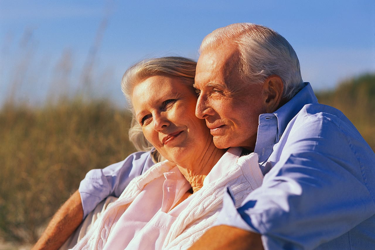 Older Couple Sitting Together at Beach